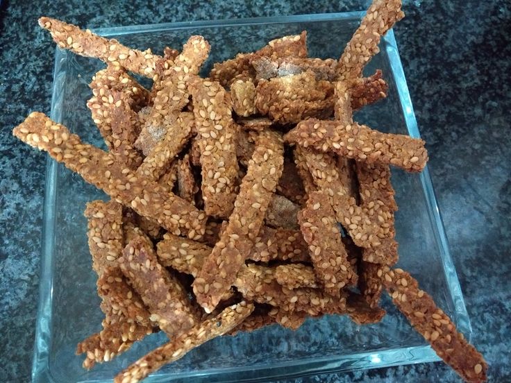 a glass bowl filled with oatmeal sticks on top of a black counter