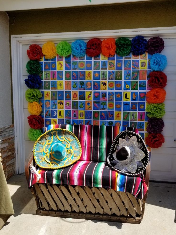 a colorful chair sitting in front of a garage door with paper flowers on the wall