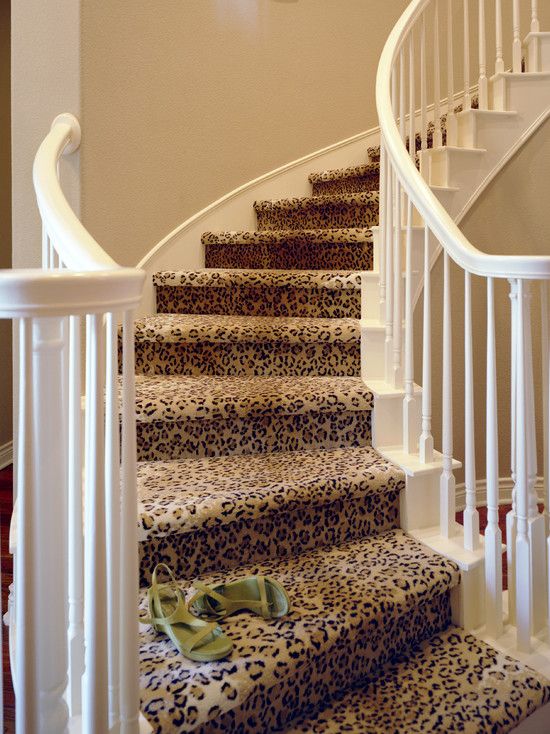 there is a leopard print rug on the stair treads in this house with white railing and handrail