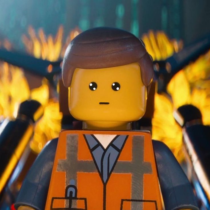 the lego movie character is wearing an orange vest and holding a black briefcase in front of flames