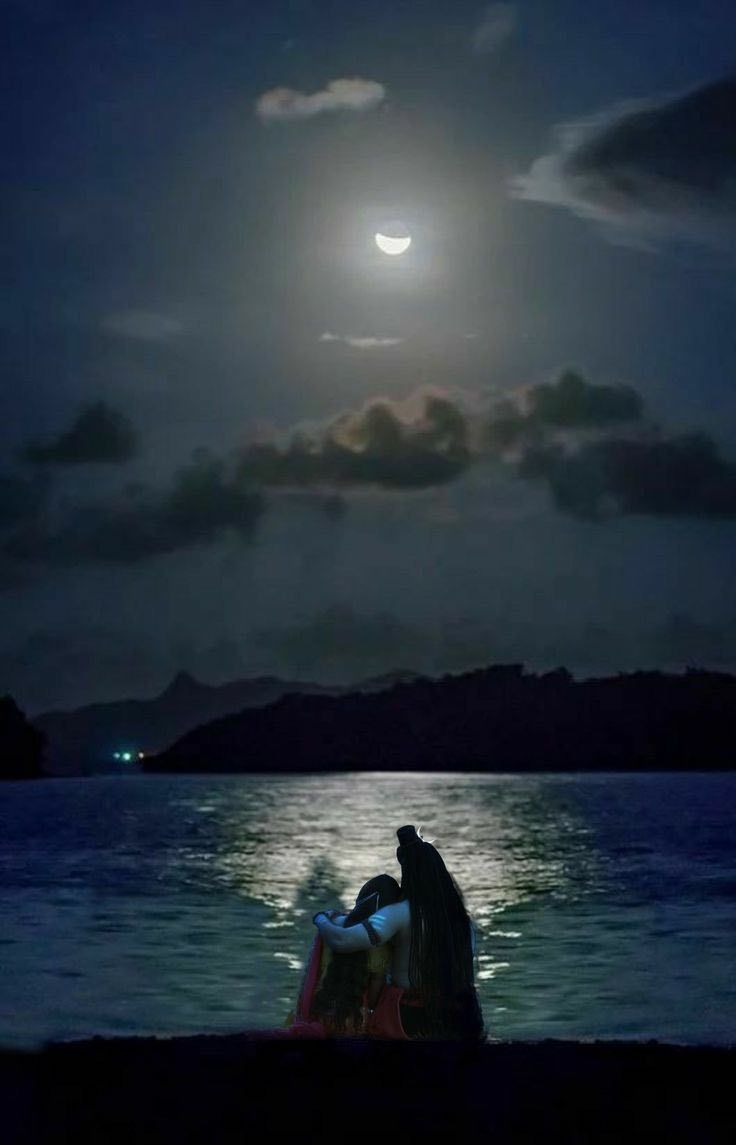 two people sitting on a boat in the water at night with the moon behind them