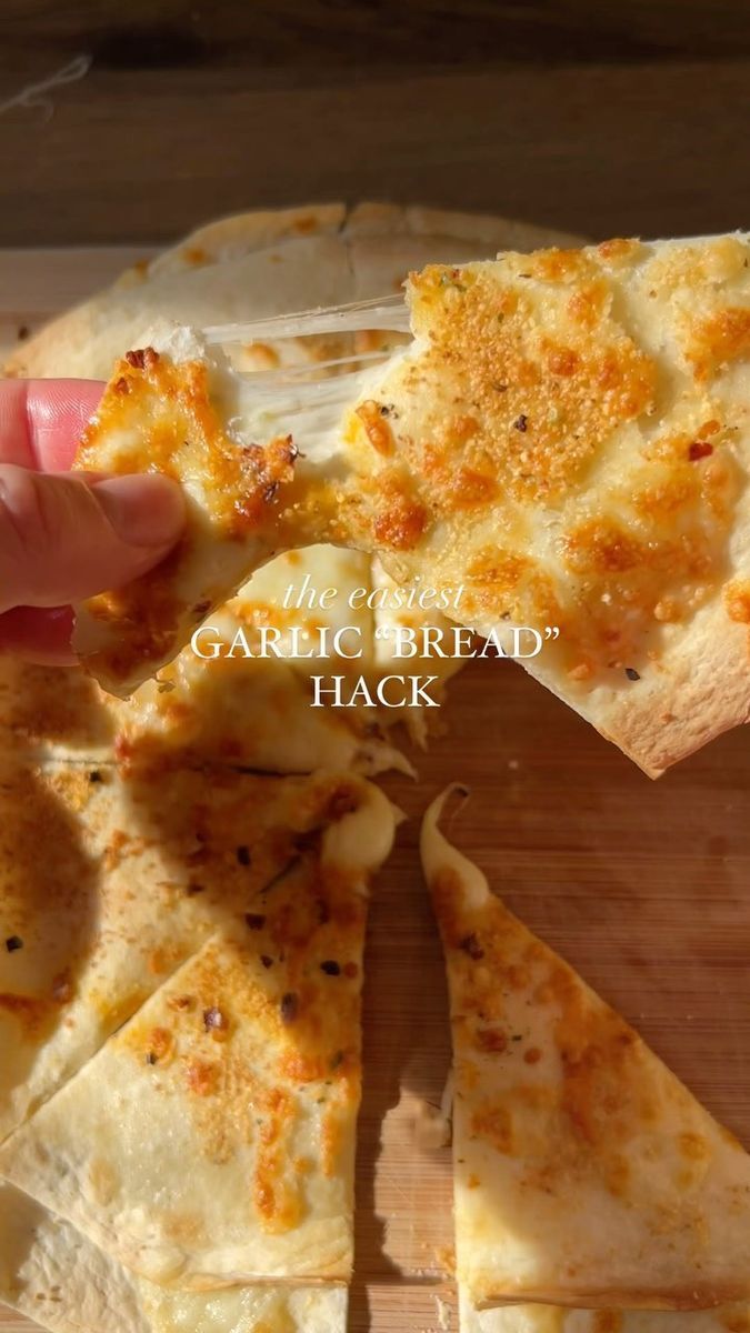 someone is taking a slice of garlic bread pizza