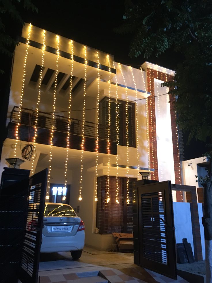 a white car parked in front of a building with lights on it