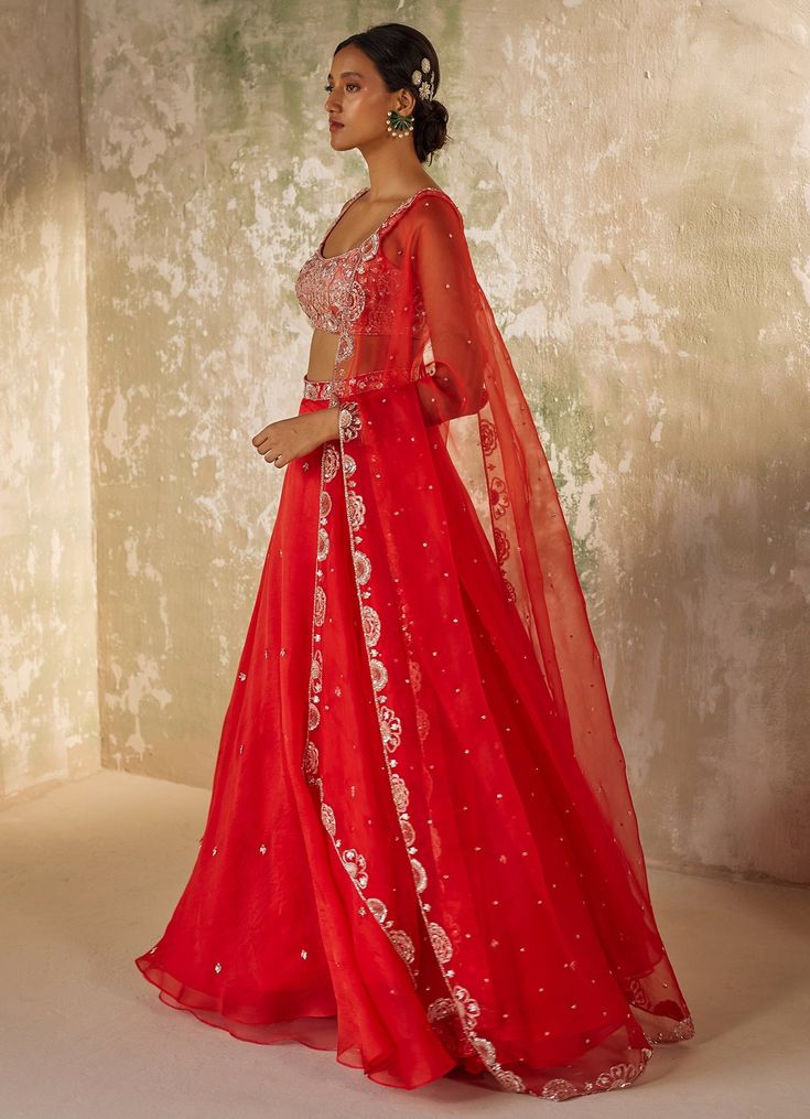 Unveil your inner elegance with the exquisite Red Embroidered Silk Organza Lehenga Set, a perfect blend of tradition and modernity. Crafted from pure silk organza, this ensemble features a red lehenga that exudes opulence through its all-over handwork motifs, adding a touch of luxury to every twirl. Paired with a delicately embroidered blouse, meticulously crafted with intricate aari handwork that showcases timeless artistry, the look is completed with a dupatta adorned with a heavily hand-embroidered border and motifs, elevating the ensemble to a new level of elegance. Perfect for a bride or bride-to-be on your special day, this outfit promises to make you the center of attention with its vibrant hue and breathtaking design. Composition : Dupatta & Lehenga - Pure Silk Organza, Blouse - Me Elegant Red Anarkali Set With Cutdana, Red Raw Silk Traditional Wear With Sheer Dupatta, Red Sharara With Sheer Dupatta In Chanderi, Red Silk Floor-length Anarkali Set, Festive Organza Lehenga For Reception, Red Festive Sets For Reception, Festive Red Sets For Reception, Red Chanderi Dress With Sheer Dupatta, Red Organza Gown With Resham Embroidery