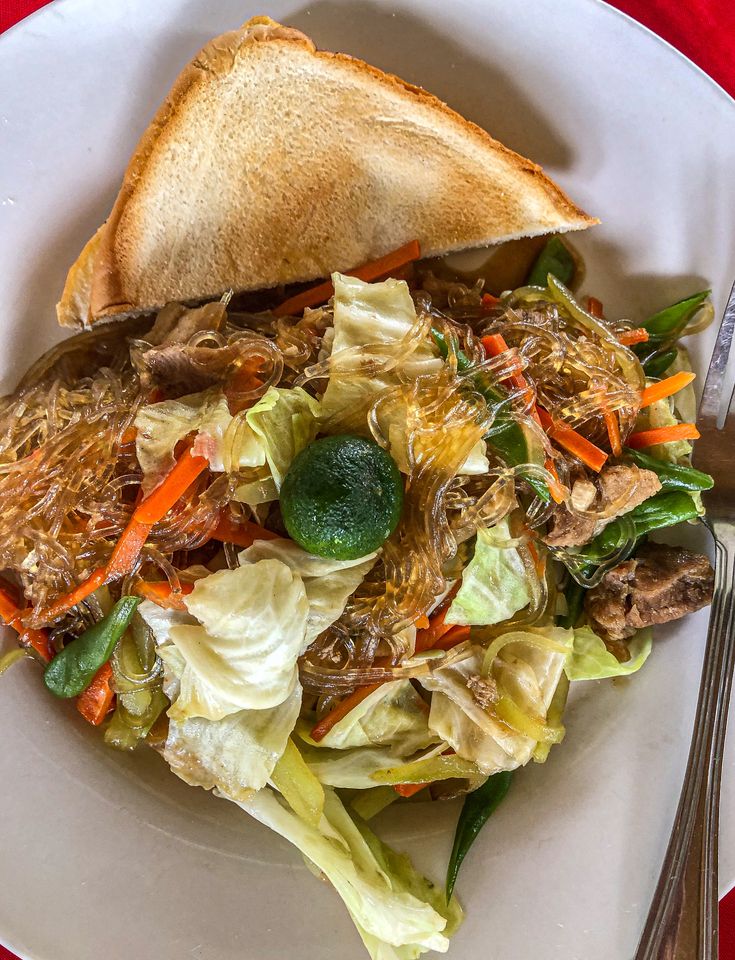 a white plate topped with a sandwich and salad