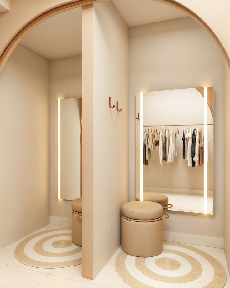 a white room with an arched doorway and clothes on racks in the closet behind it