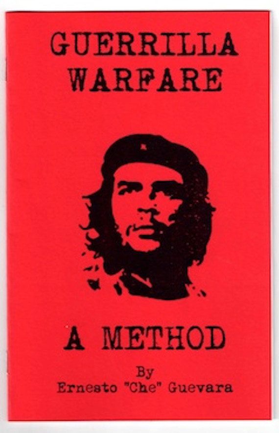 a red book with the title guerrilla warfare, written in black ink on it