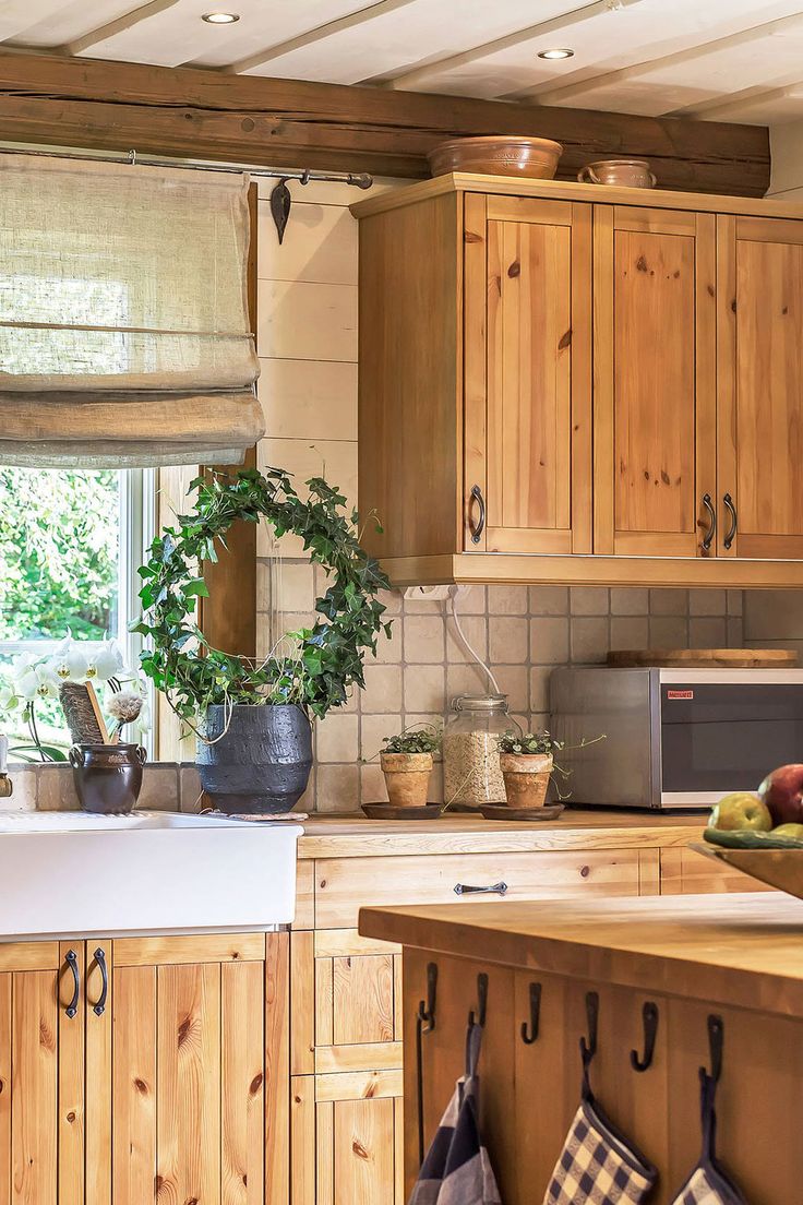 a kitchen filled with wooden cabinets and counter top next to a sink under a window