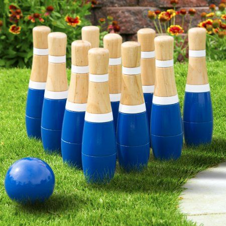 blue and white bowling pins lined up in the grass