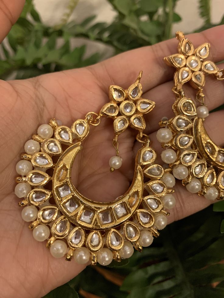 Premium quality gold-plated kundan chandbali earrings with moti (pearls). Very gorgeous pair. Care Instruction: Avoid heat & substances like perfume, deodorant, alcohol, etc and clean with silver/gold polish cloth. Store in airtight spaces like ziplock pouch or jewelry box. Golden Chandbali Earrings, Luxury Tilla Chandbali Bridal Earrings, Luxury Gold Plated Bollywood Chandbalis, Luxury Festive Kundan Chandbalis, Luxury Chandbalis For Eid, Luxury Festive Chandbalis For Party, Luxury Gold Hoop Earrings With Latkans, Luxury Gold-plated Chandbalis For Celebration, Luxury 22k Gold Chandbali Kundan Necklace