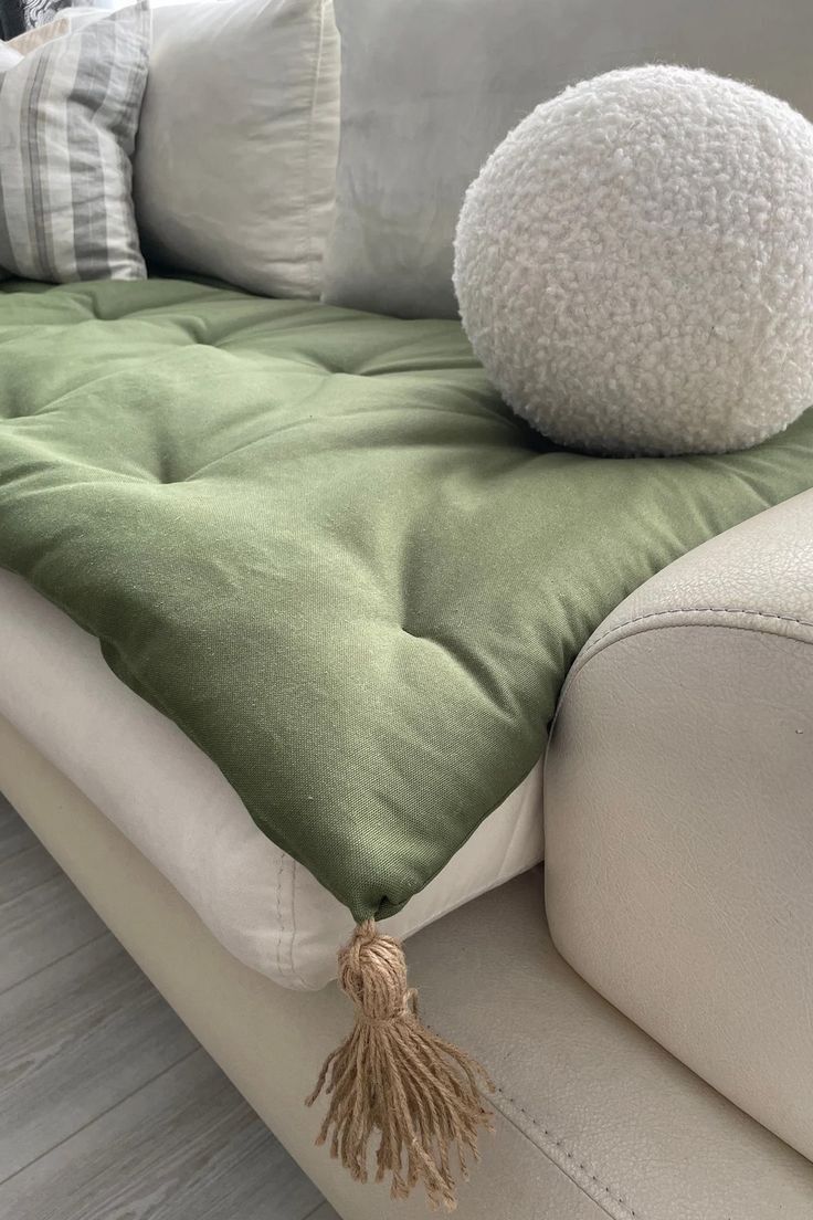 a green and white couch with pillows on it