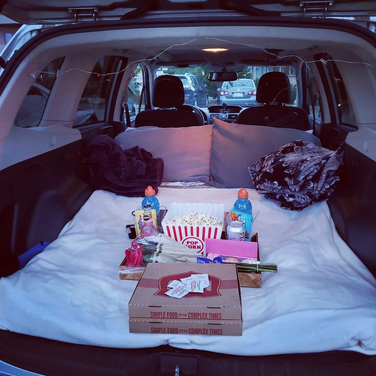 the back of a car with an open trunk filled with food and drinks in it