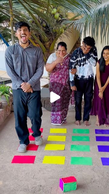 a group of people standing next to each other in front of colorful squares on the ground