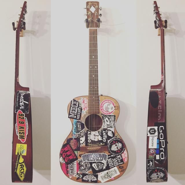 two guitars with stickers on them and one has a guitar case attached to it