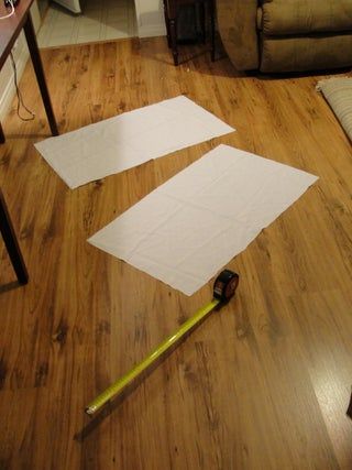 two pieces of paper are laying on the floor next to a pair of tape measures