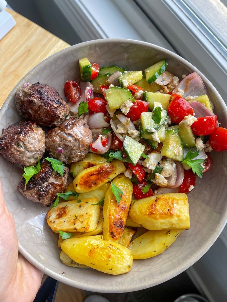 a white bowl filled with meat and veggies