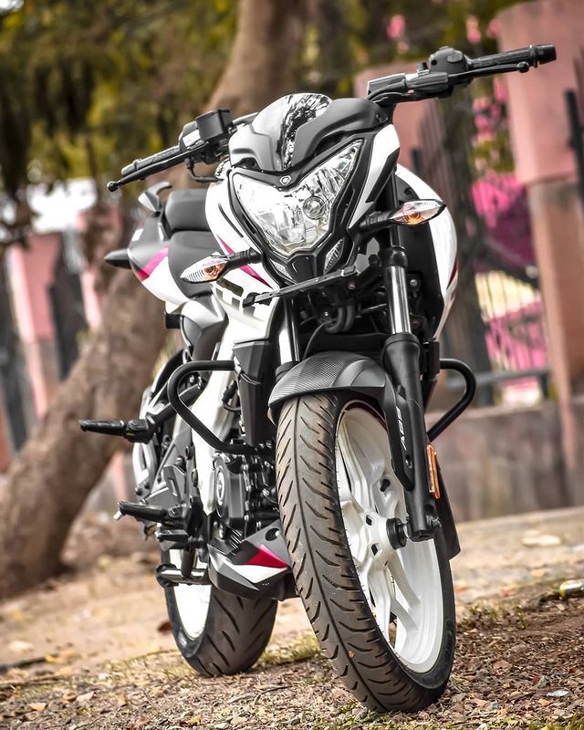 a white and black motorcycle parked in front of a tree