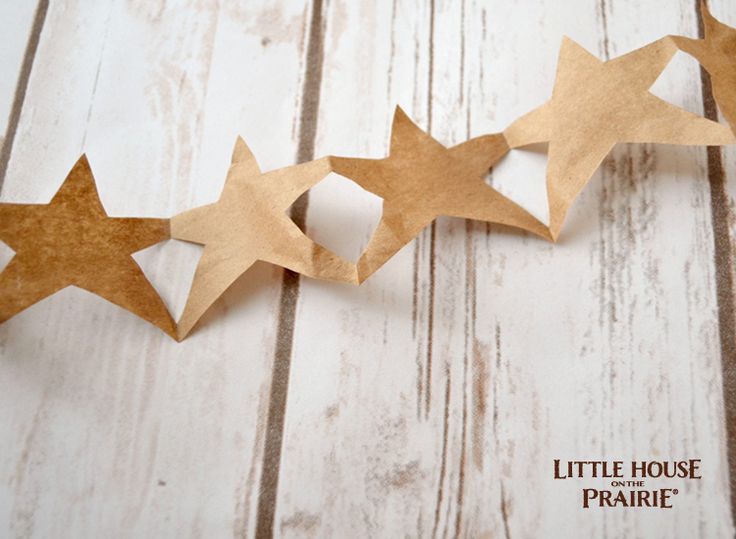 some brown paper stars on a white wooden table with the words little house prairie written in it