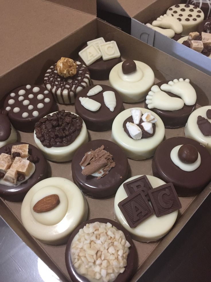 a box filled with lots of different types of cupcakes on top of a table