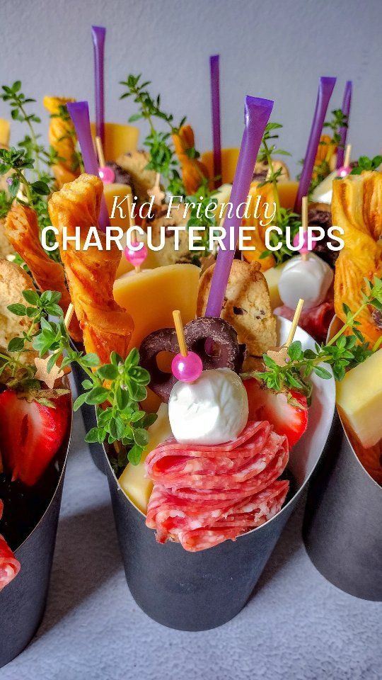 four cups filled with different types of food and garnished with purple strawberries