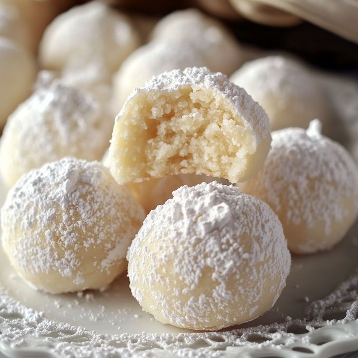 powdered sugar covered donuts on a white plate