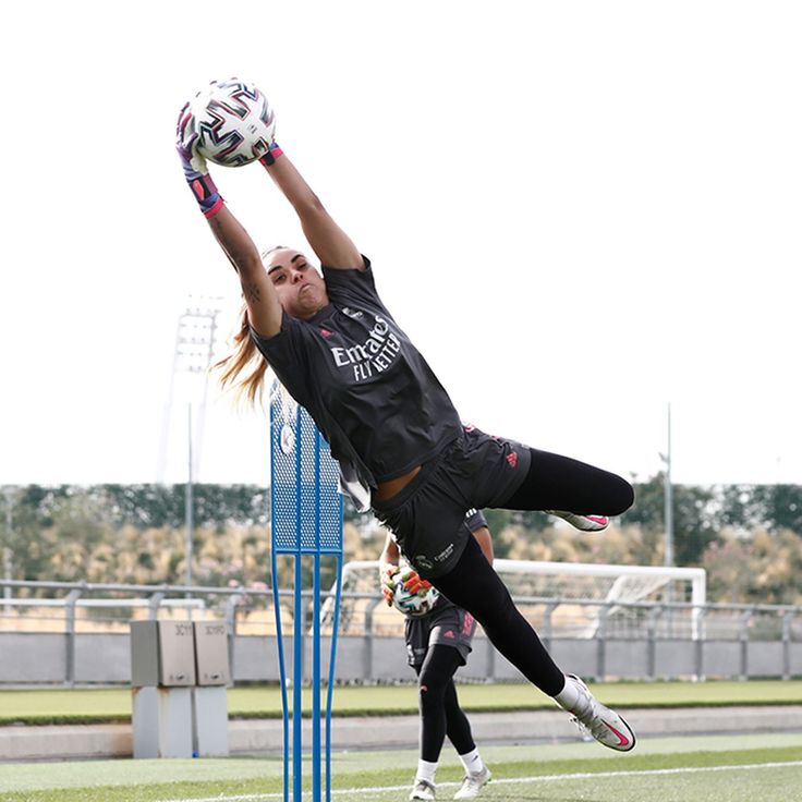 a person jumping up in the air to catch a soccer ball with their hands and legs