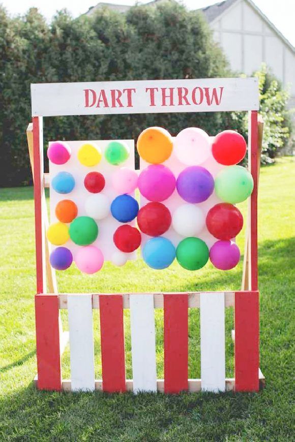 a sign that says dart throw with balloons attached to the back of it in front of some grass