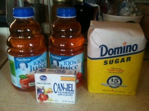 two bottles of juice sitting on top of a counter next to a carton of orange juice