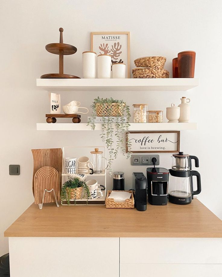 a kitchen counter with coffee cups and other items on it's shelf above the stove