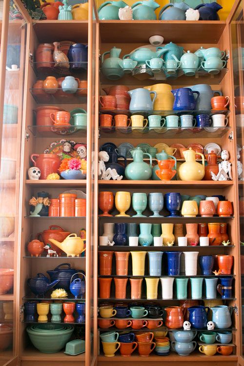 shelves filled with lots of colorful dishes and cups