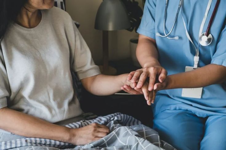 a nurse holding the hand of a patient