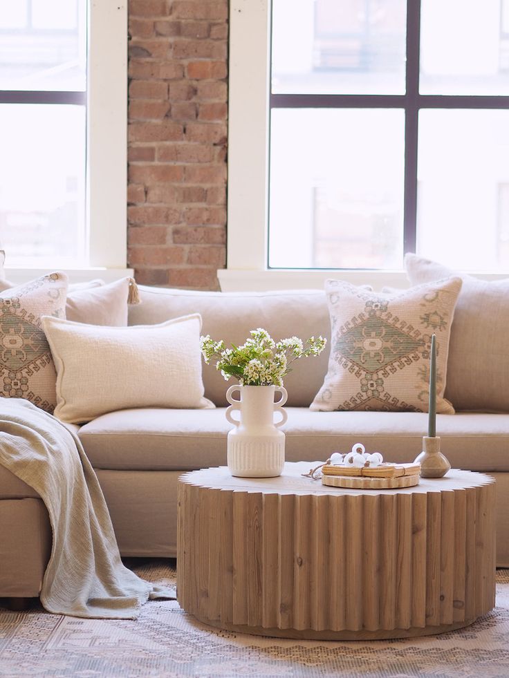 a living room with a couch, table and window in it's center area