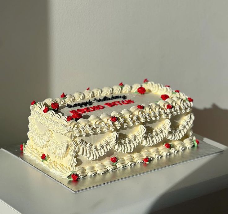 a large white cake with red and green decorations on the top is sitting on a table