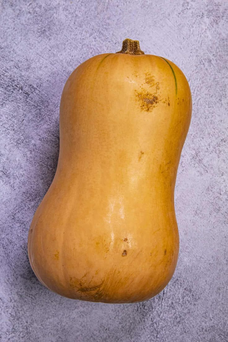 a yellow gourd sitting on top of a cement floor