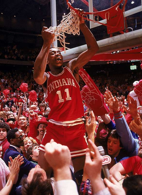 a basketball player dunking the ball in front of an arena full of people holding their hands up