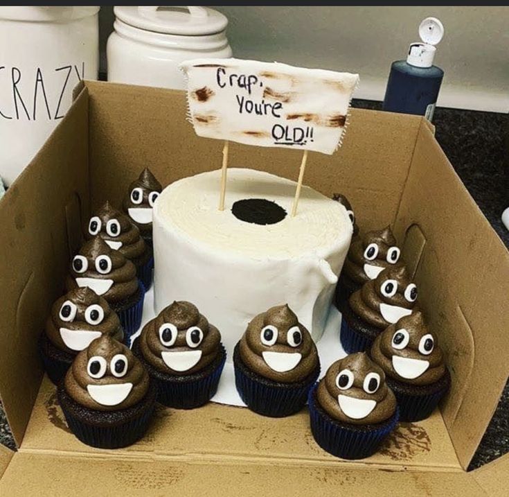 cupcakes with googly eyes are in a cardboard box