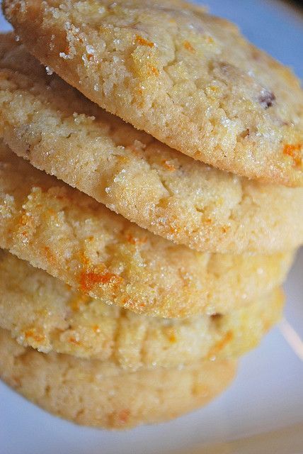 three cookies stacked on top of each other on a white plate with orange sprinkles