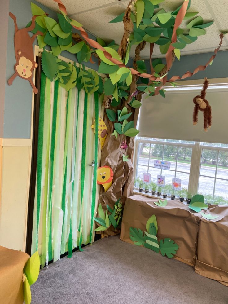 a room decorated in green and brown with monkeys hanging from the ceiling, curtains on the windows