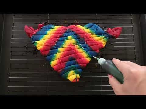 someone is using a marker to draw on a colorful piece of fabric that looks like a fish