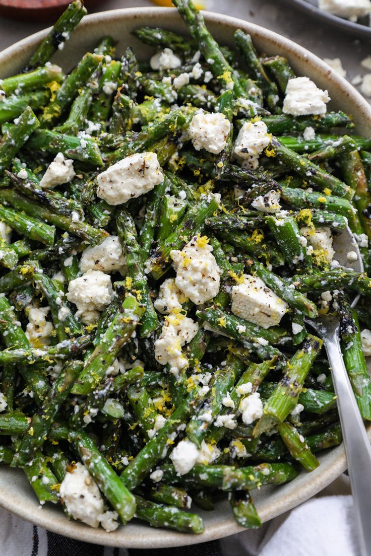 a bowl filled with asparagus and feta cheese