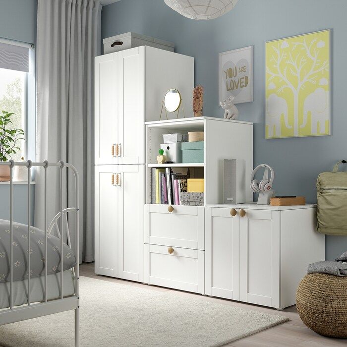 a bedroom with blue walls and white furniture