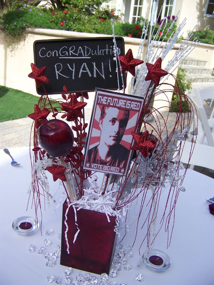 a table topped with an apple and flowers next to a sign that says congratulations ryan