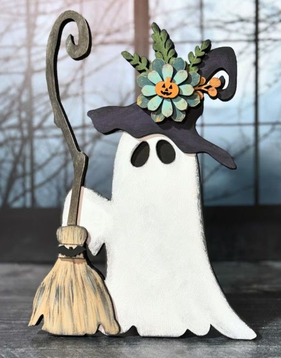 a halloween decoration with a ghost holding a broom