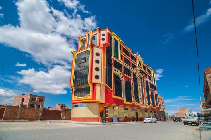 a multicolored building with cars parked in front