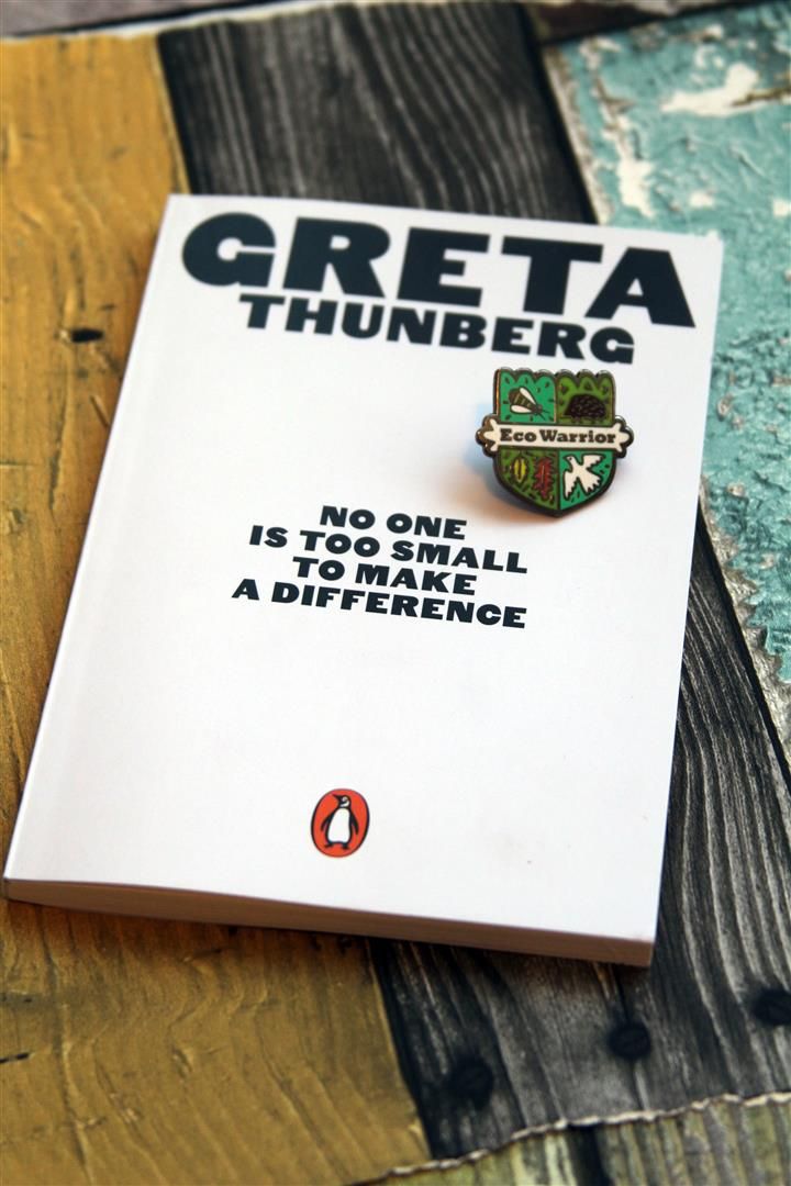 there is a book with a pin on it that says greta thunberg