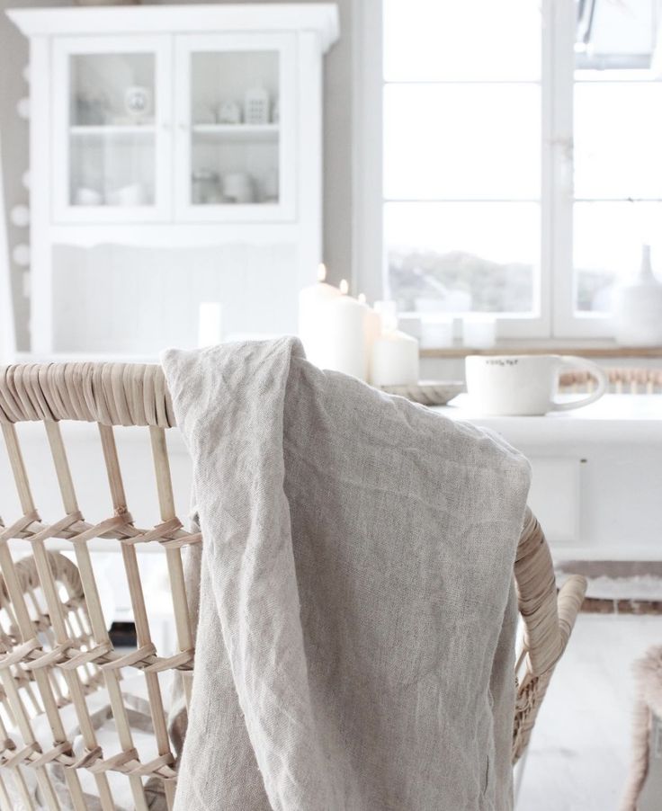 a chair with a blanket on top of it in front of a table and chairs