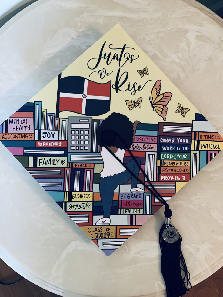 a decorated graduation cap with an illustration of a woman in front of books and butterflies