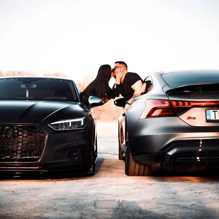 a man leaning on the hood of a black car