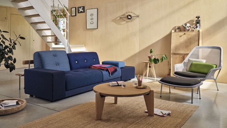 a living room filled with furniture next to a stair case