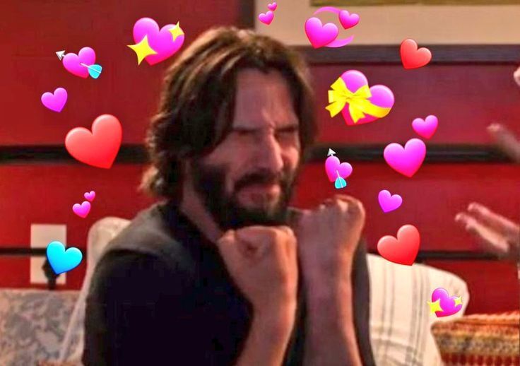 a man with long hair and beard sitting on a couch in front of many hearts